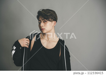 グレーバックの背景で上着を羽織っている男性 グレーバックの背景で上着を羽織っている男性 112336415