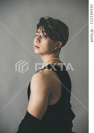 グレーバックの背景で上着を羽織っている男性 112336430