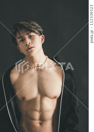 上半身の筋肉を見せる若い男性 上半身の筋肉を見せる若い男性 112336523