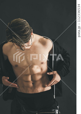 筋肉がすごいメガネをかけた若い男性の上半身 112336534