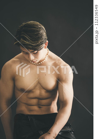 黒背景で上半身裸の筋肉質な若い男性 112336549