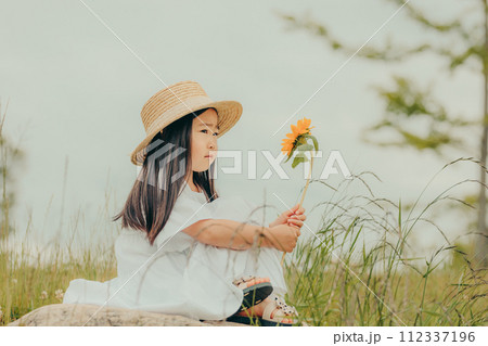 ひまわりを持った女の子 112337196