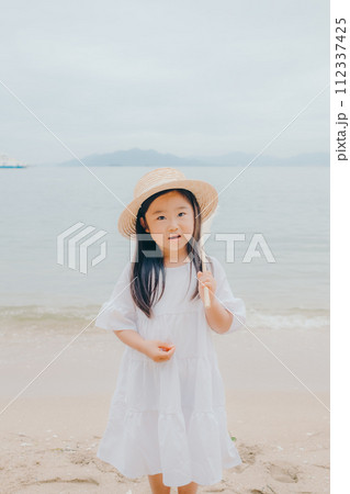 海辺でドライフラワーを持った女の子 112337425