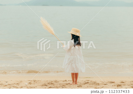 海辺でドライフラワーを持った女の子 112337433