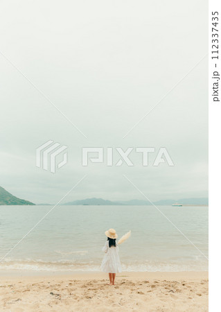 海辺でドライフラワーを持った女の子 112337435