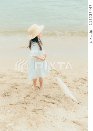 海辺でドライフラワーを持った女の子 112337447