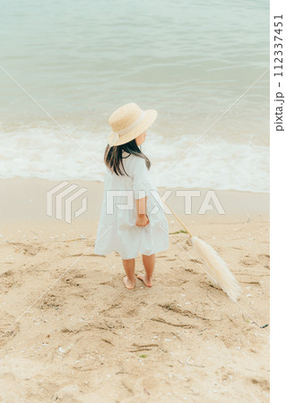 海辺でドライフラワーを持った女の子 112337451