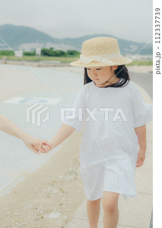 母親と手を繋いで歩く女の子 母親と手を繋いで歩く女の子 112337739