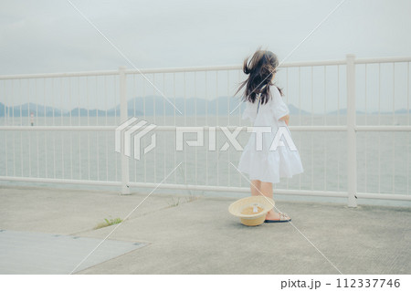 フィルムカメラを持って佇む女の子 112337746