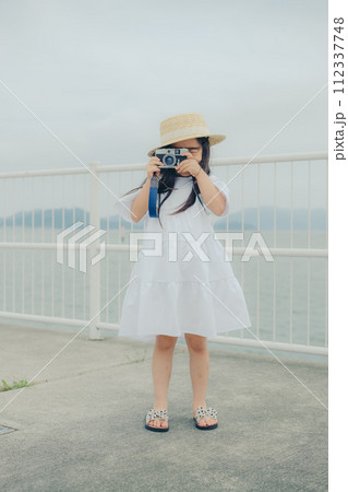 フィルムカメラを持って佇む女の子 フィルムカメラを持って佇む女の子 112337748