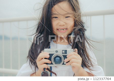フィルムカメラを持って佇む女の子 フィルムカメラを持って佇む女の子 112337764