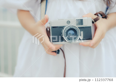 フィルムカメラを持って佇む女の子 112337768