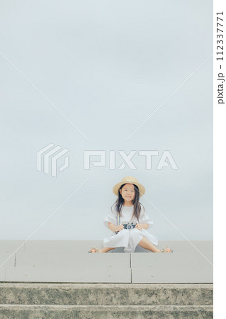 フィルムカメラを持って佇む女の子 112337771