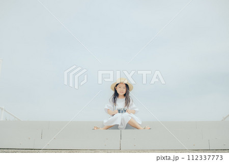 フィルムカメラを持って佇む女の子 112337773