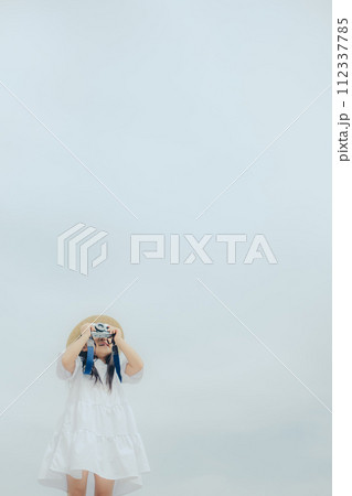 フィルムカメラを持って佇む女の子 112337785