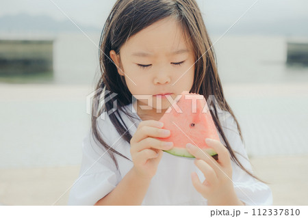 浜辺でスイカを食べる女の子 浜辺でスイカを食べる女の子 112337810