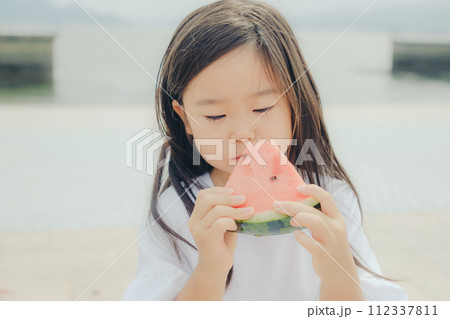 浜辺でスイカを食べる女の子 浜辺でスイカを食べる女の子 112337811