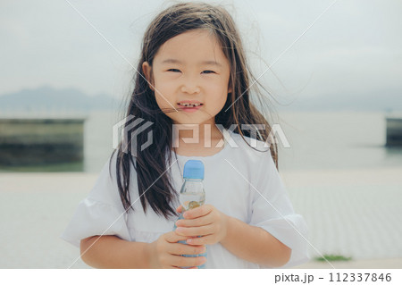 ラムネの瓶を持つ女の子 112337846