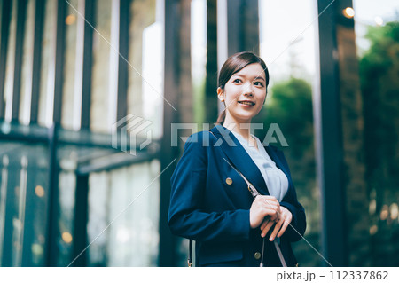 オフィスビルを背景にしたビジネスウーマン 112337862
