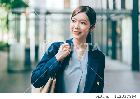 オフィスビルを背景にしたビジネスウーマン 112337894