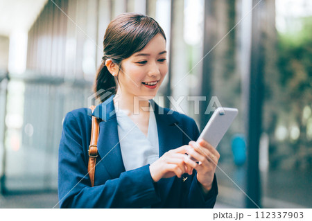 屋外でスマホを持つ若い女性 112337903