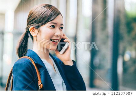 屋外で電話をする若い女性 112337907