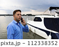 Man talking on the phone beside luxury yacht at port. Nautical and marine concept 112338352
