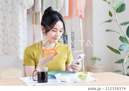 朝食を食べる若い女性 112338374