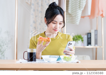 朝食を食べる若い女性 朝食を食べる若い女性 112338380