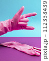 Hand in Pink latex glove showing devil, heavy metal or rock and roll sign 112338439