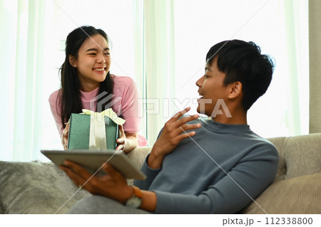 Surprised young asian man receiving a gift from his wife for wedding anniversary or birthday 112338800