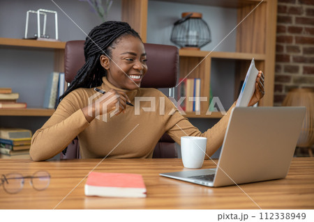 Cheerful woman with dreadlocks works remotely using laptop and technology 112338949