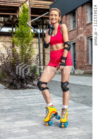 Pretty woman on rollerblades posing in park Pretty woman on rollerblades posing in park 112339814