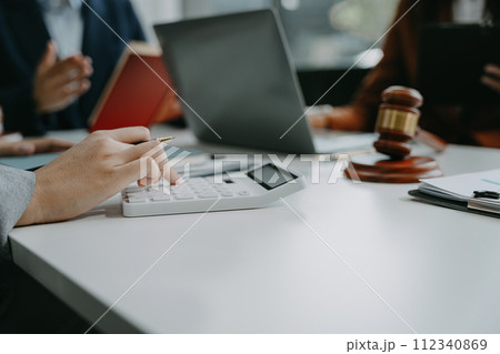Lawyer or accounting department writes a note and uses a calculator to calculate expenses - income. at office lawyer. 112340869