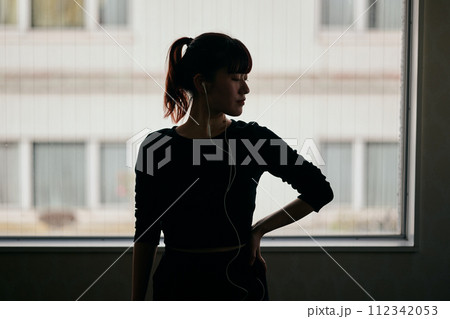 音楽を聴きながらダンスの練習をする若い女性 112342053