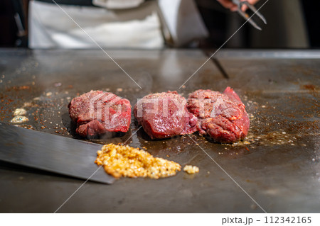 【#鉄板焼】ステーキ肉を焼くシェフの手元 112342165