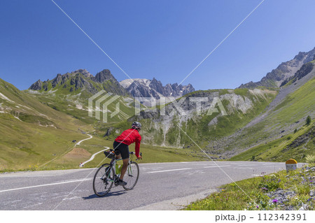 cyclist on route des Grandes Alpes near Col du Galibier, Hautes-Alpes, France 112342391