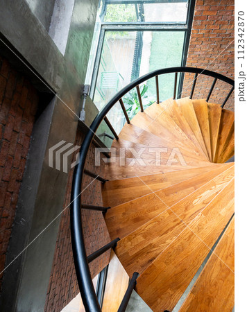 Wooden spiral staircase with the metal railing. 112342870
