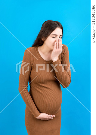 Pregnant woman suffering from toxicosis. Toxicosis Of Pregnancy. Pregnant Lady Feeling Sick Having Nausea Standing On Colored isolated Background. Free Space 112343366