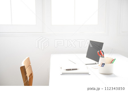 白い窓際にノートパソコンとステーショナリーのあるイメージ 112343850