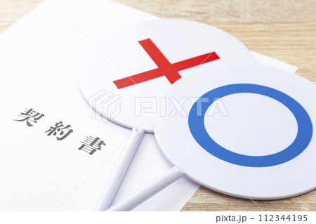 机に置かれた契約書とマルバツ札 机に置かれた契約書とマルバツ札 112344195