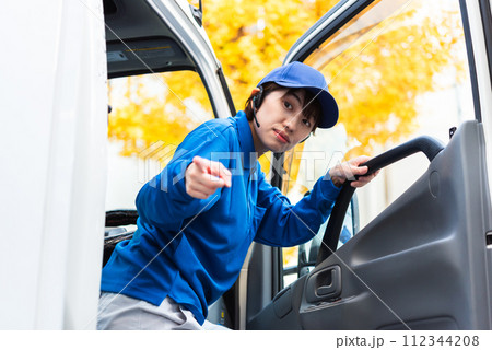 後方の安全確認をするトラックドライバーの女性 112344208