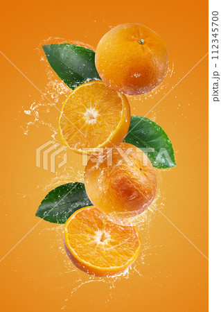 Water splashing on Fresh Sliced oranges and Orange fruit on a Orange background Water splashing on Fresh Sliced oranges and Orange fruit on a Orange background 112345700
