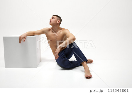 Handsome young guy with healthy, relief, muscular body posing in jeans isolated over white studio background Handsome young guy with healthy, relief, muscular body posing in jeans isolated over white studio background 112345801