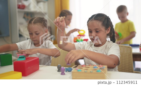 child group playing fishing. children in kindergarten play with toys. happy family kid dream concept. a group of children collect building blocks in a lifestyle kindergarten indoors child group playing fishing. children in kindergarten play with toys. happy family kid dream concept. a group of children collect building blocks in a lifestyle kindergarten indoors 112345911
