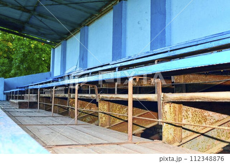 Old grandstand seats. Vintage tone. Old blue wooden grandstand stadium Old grandstand seats. Vintage tone. Old blue wooden grandstand stadium 112348876