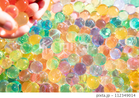 Colored balls of hydrogel touch children's hands. Sensory sensations. Colored balls of hydrogel touch children's hands. Sensory sensations. 112349014