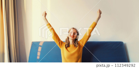 Happy cheerful young woman listening to music with headphones having fun at home 112349292