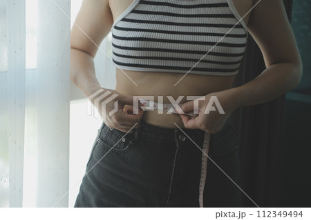 Women body fat belly. Obese woman hand holding excessive belly fat. diet lifestyle concept to reduce belly and shape up healthy stomach muscle. 112349494