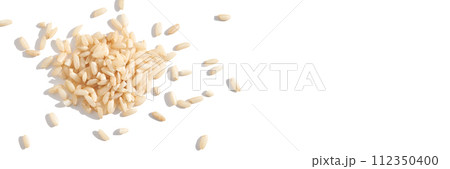 A top view of raw brown and white rice, forming a heap. The integral, uncooked 112350400